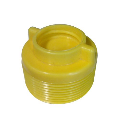 A yellow plastic cap that is sitting on the ground.